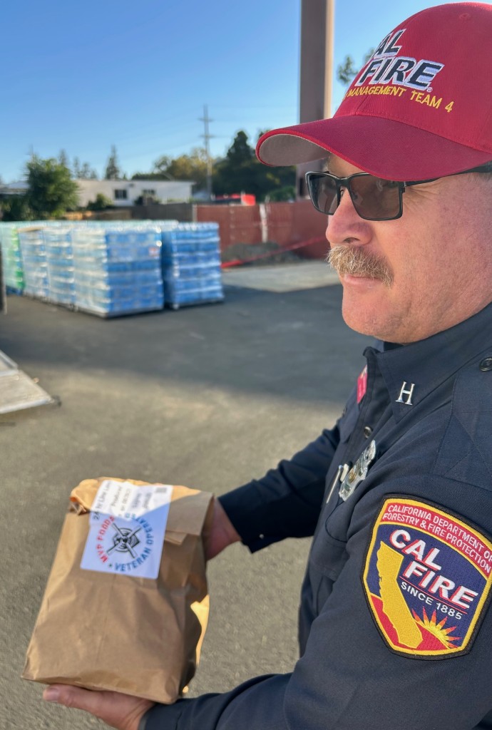 Jesse McGuire, a Cal Fire food unit leader, holds one of the lunch bags handed out to firefighters. Firefighters may need as much as 6,000 calories per shift. Kerana Todorov photo