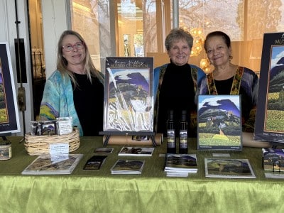 Heather Hamilton, Jessel Miller and Nouria Harris stand with copies of this year's poster art at the sold-out Jan. 17 launch of the 2026 Mustard Celebration held at Silverado Resort. Submitted photo