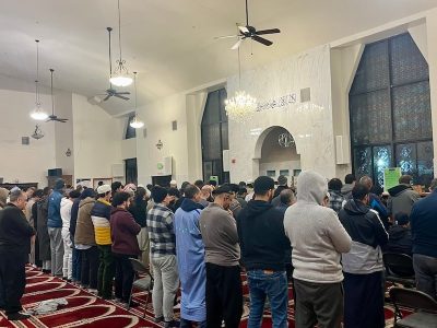 group of men stand in prayer in mosque