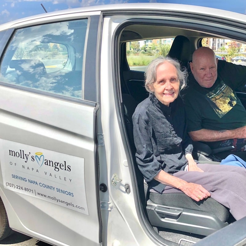two elder adults in a van