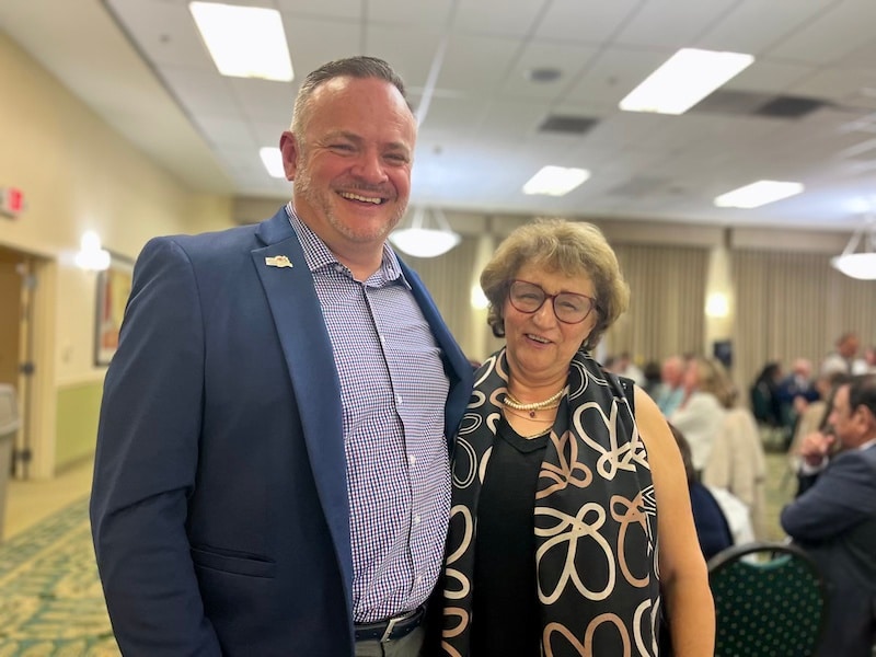 two people smiling and looking at the camera