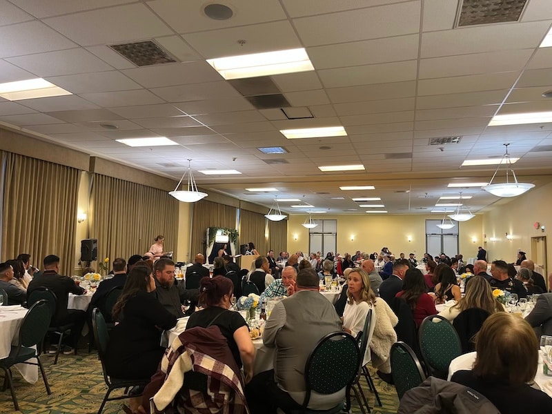 roomful of people eating and talking at dinner tables